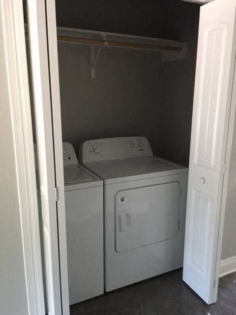 a white washer and dryer in a small closet