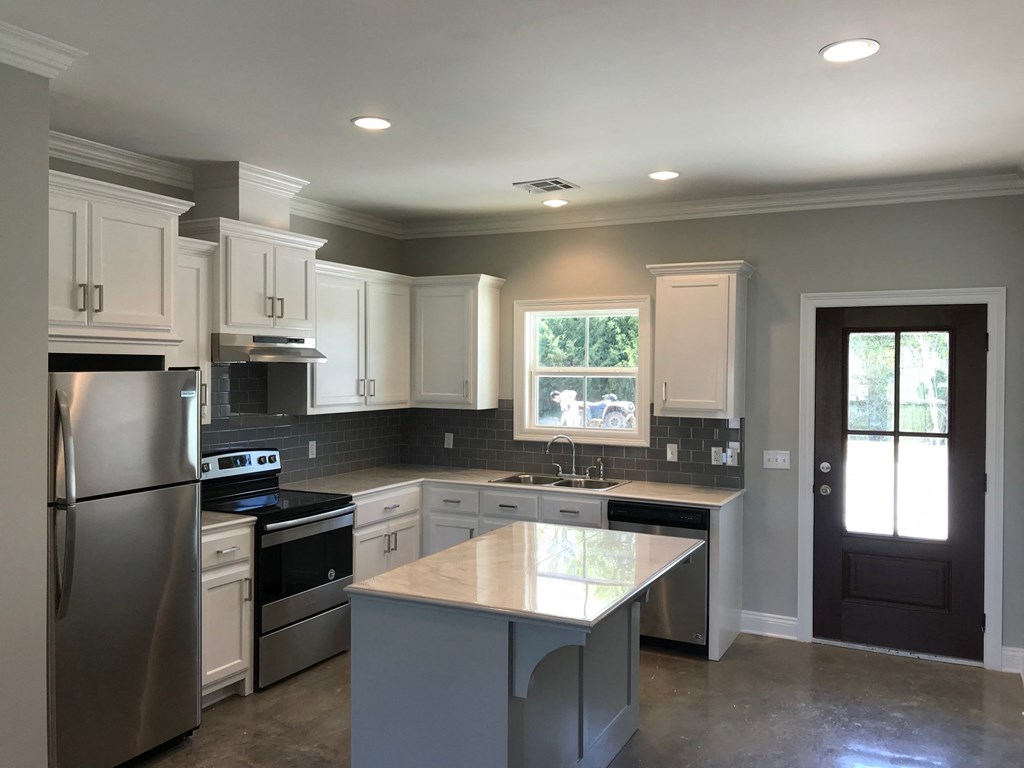 a kitchen remodel with white cabinets and stainless steel appliances