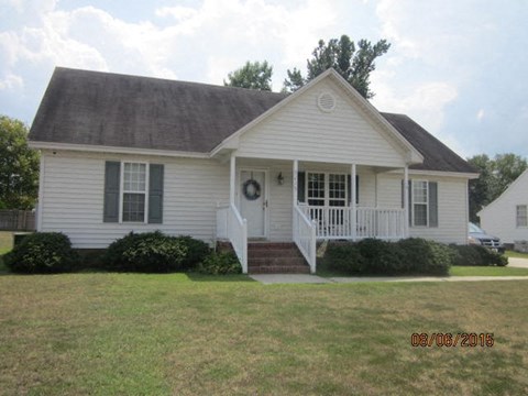 a white house with a porch and a lawn