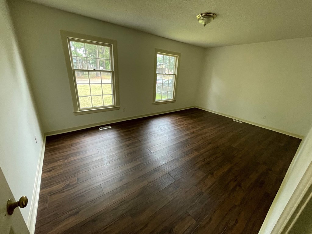 an empty living room with a hard wood floor