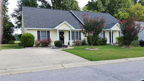 a yellow house with a blue roof on a street