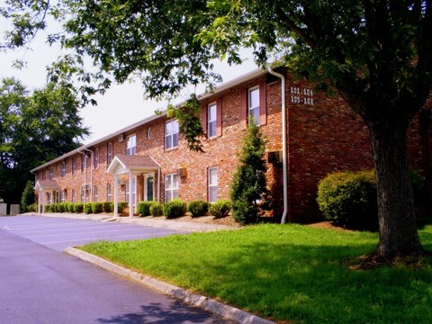 Apartment building with green grass in front.