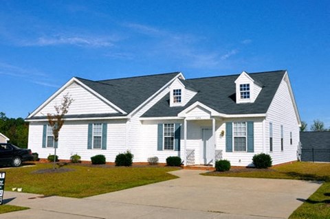a white house with a gray roof and a driveway