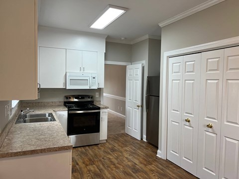 A kitchen with white cabinets and a stainless steel oven.