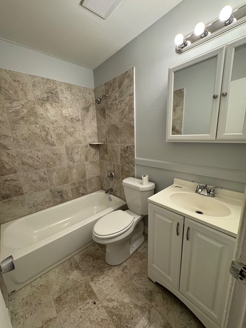A bathroom with a toilet, sink, and bathtub.