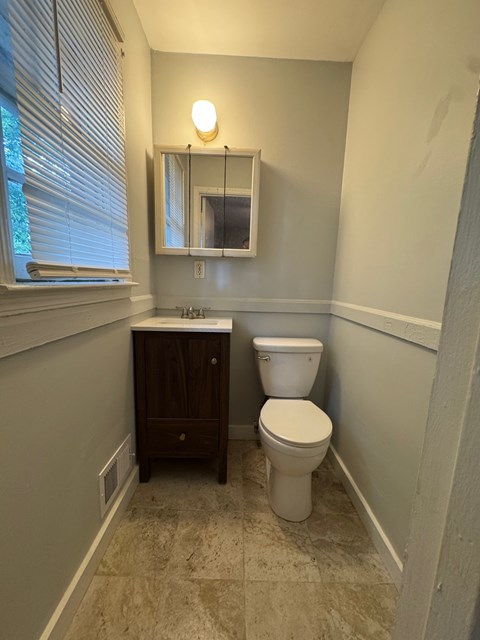 A bathroom with a toilet and a cabinet.