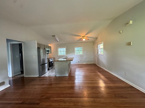 A kitchen with a refrigerator, sink, and a window.