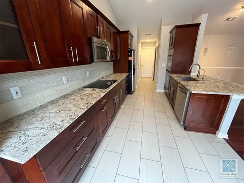a large kitchen with marble counter tops and wooden cabinets