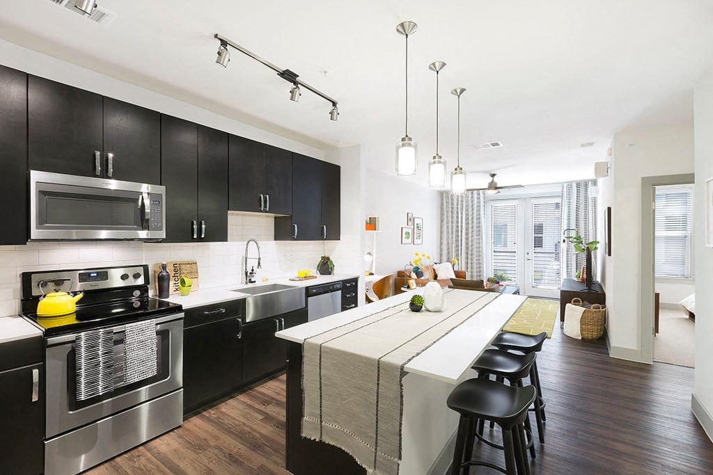 a large kitchen with black cabinets and a white counter top