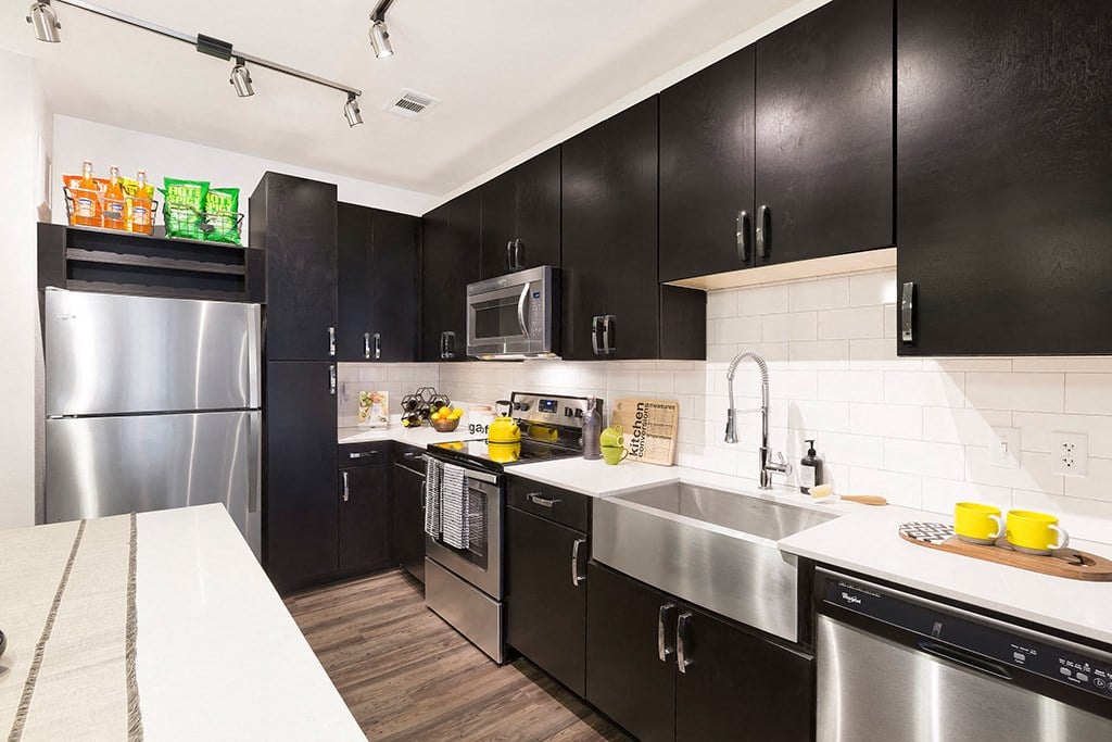 a kitchen with stainless steel appliances and black cabinets