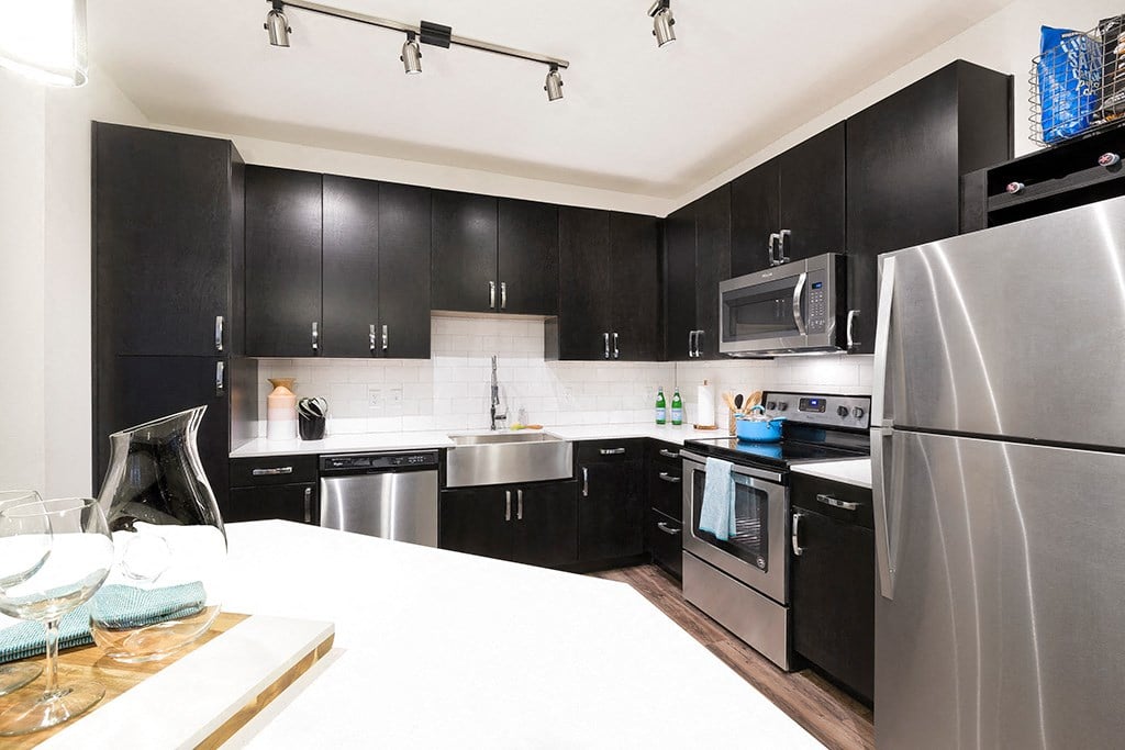 a kitchen with stainless steel appliances and black cabinets