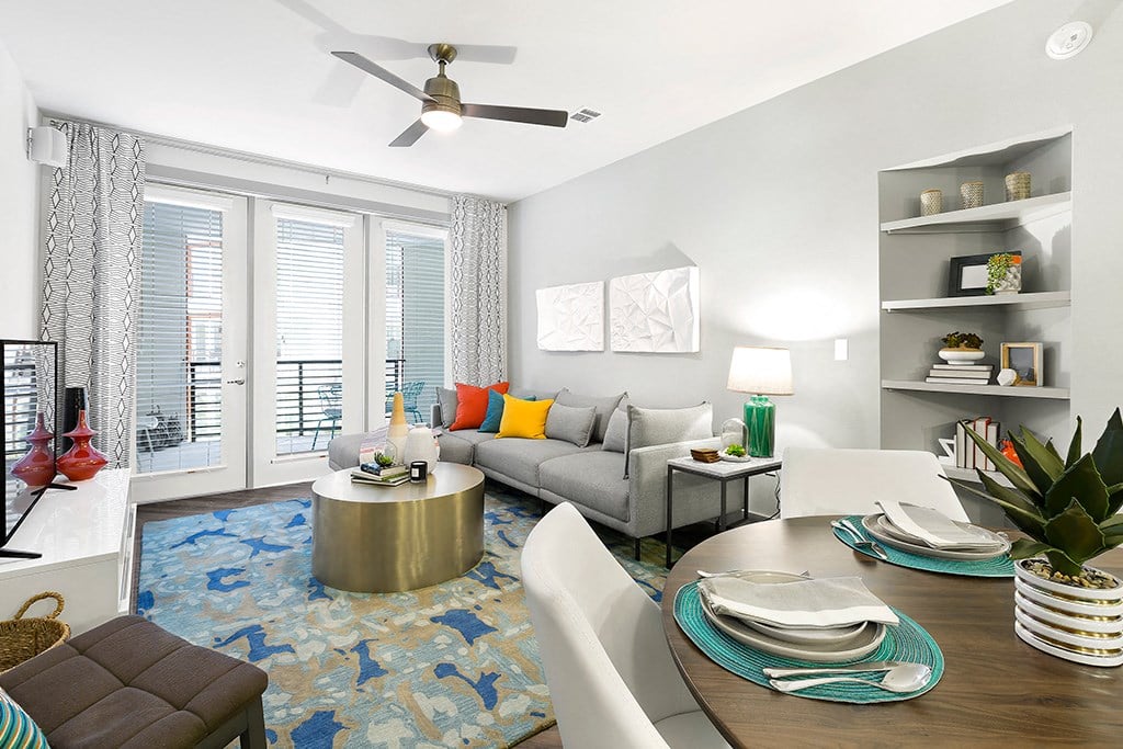 a living room with a couch and a table and a ceiling fan