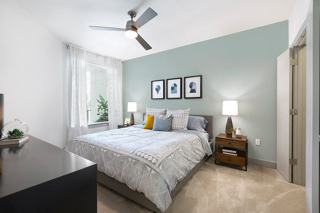 a bedroom with a bed and a ceiling fan