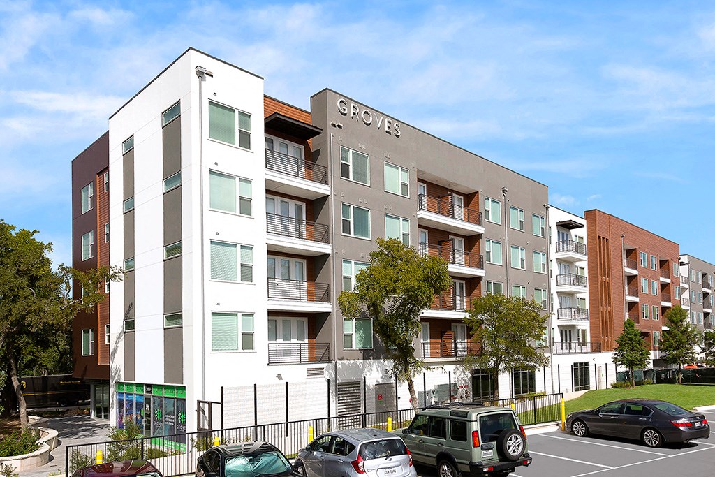 a new apartment building with cars parked in front of it