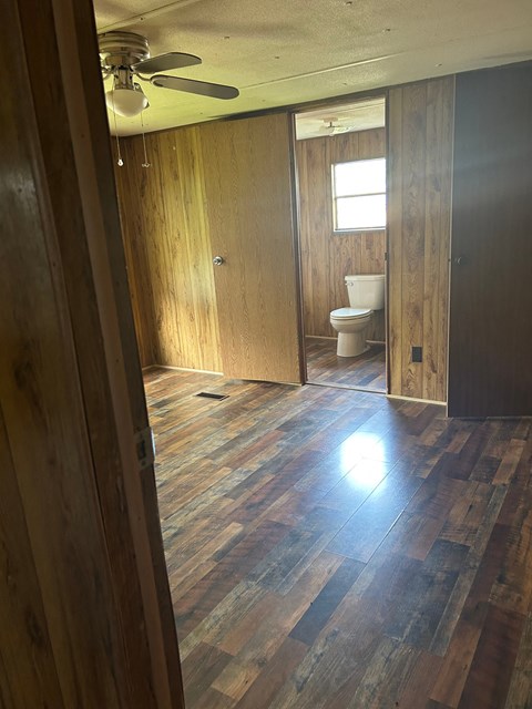 A room with wooden floors and a ceiling fan.