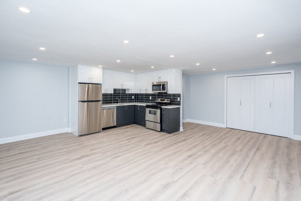 an empty living room with a kitchen in it