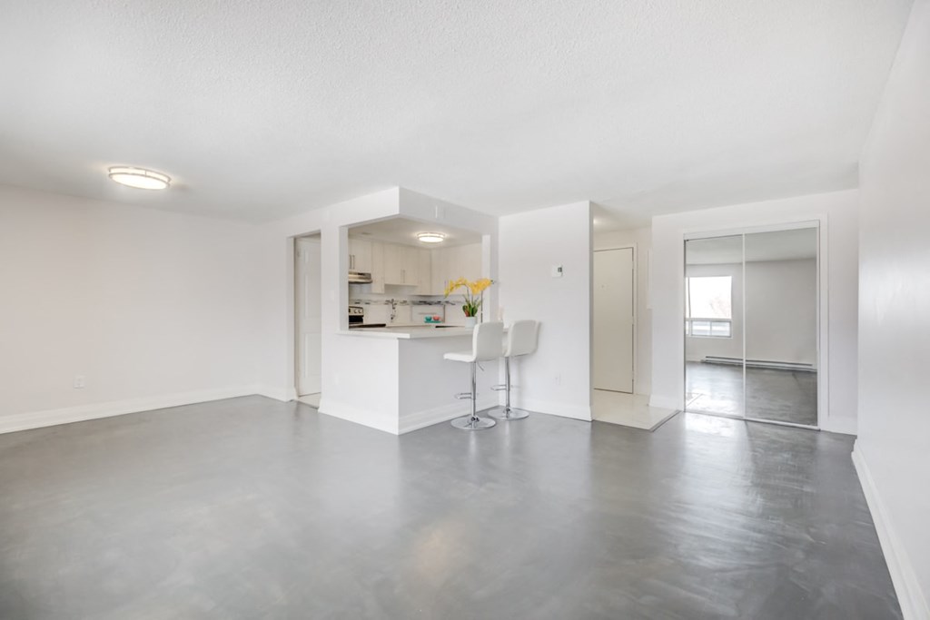 the living room and kitchen of an empty apartment