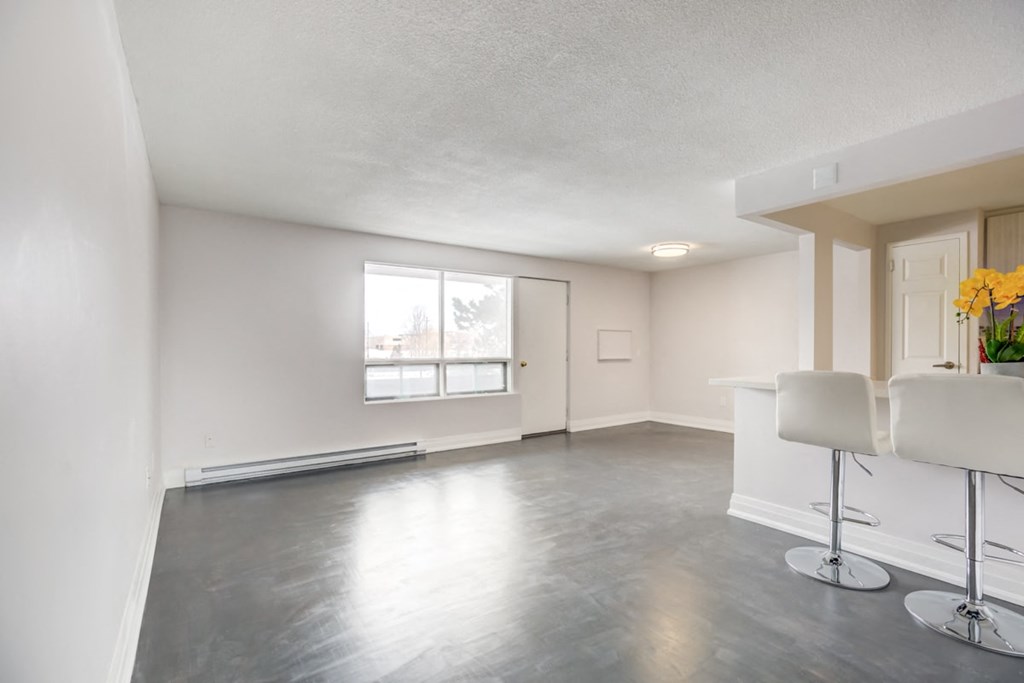 an empty living room with white walls and a window
