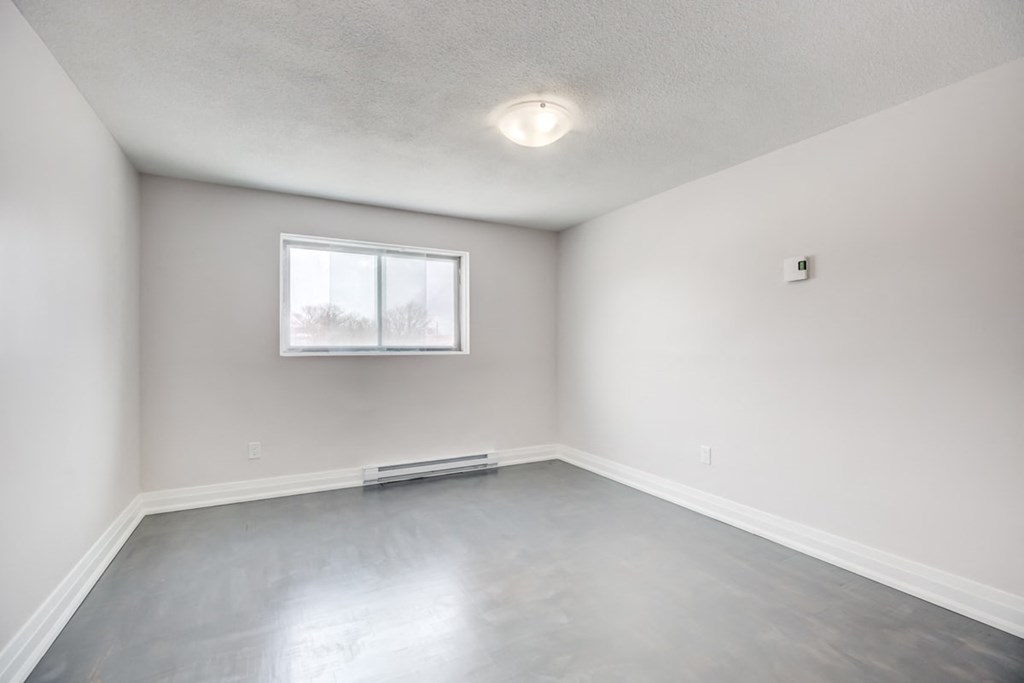 an empty room with white walls and a window