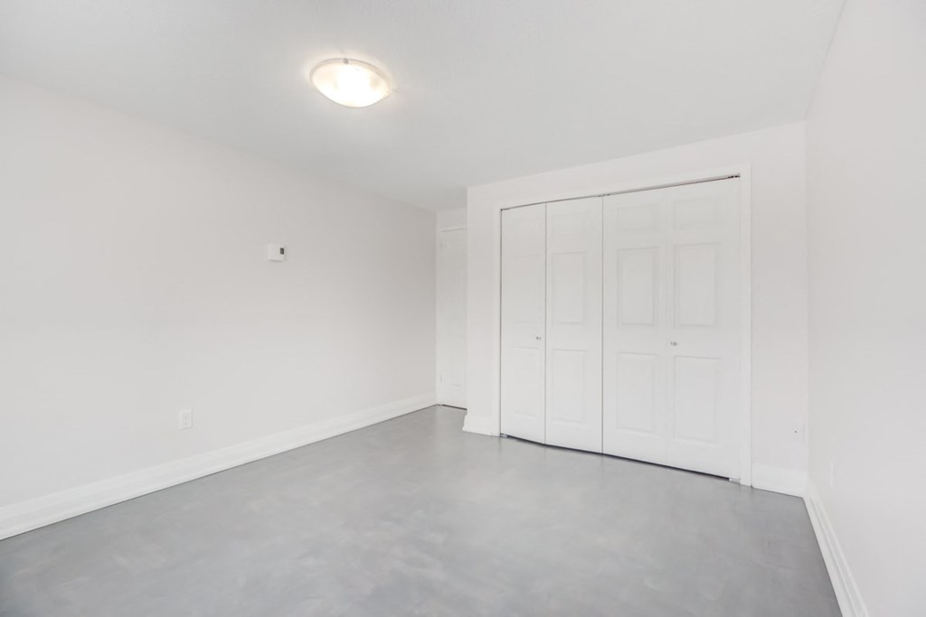 an empty room with white walls and a white door