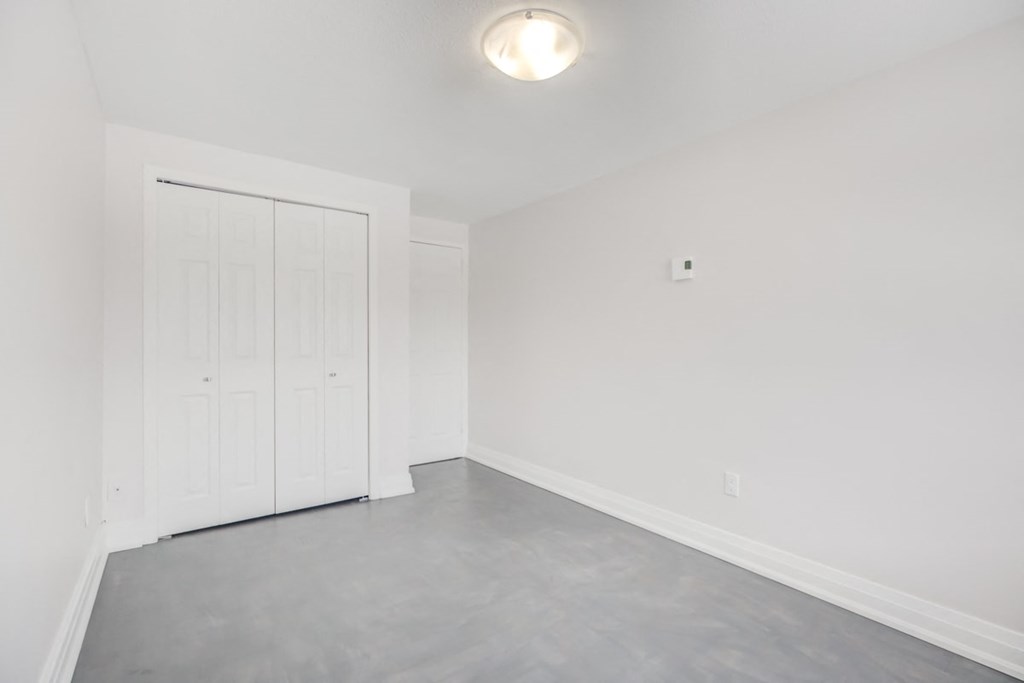the living room is empty and has white walls and a white door