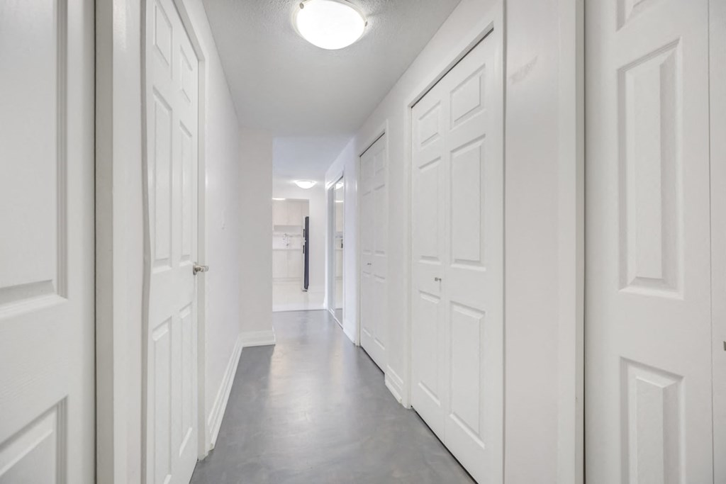 a long white hallway with white doors and white walls