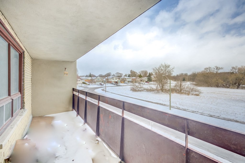 the view from the balcony of a home with snow on the ground