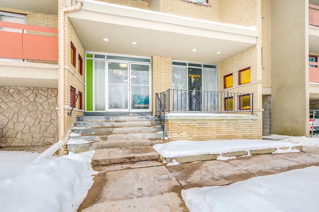 the front entrance of a house with snow on the steps