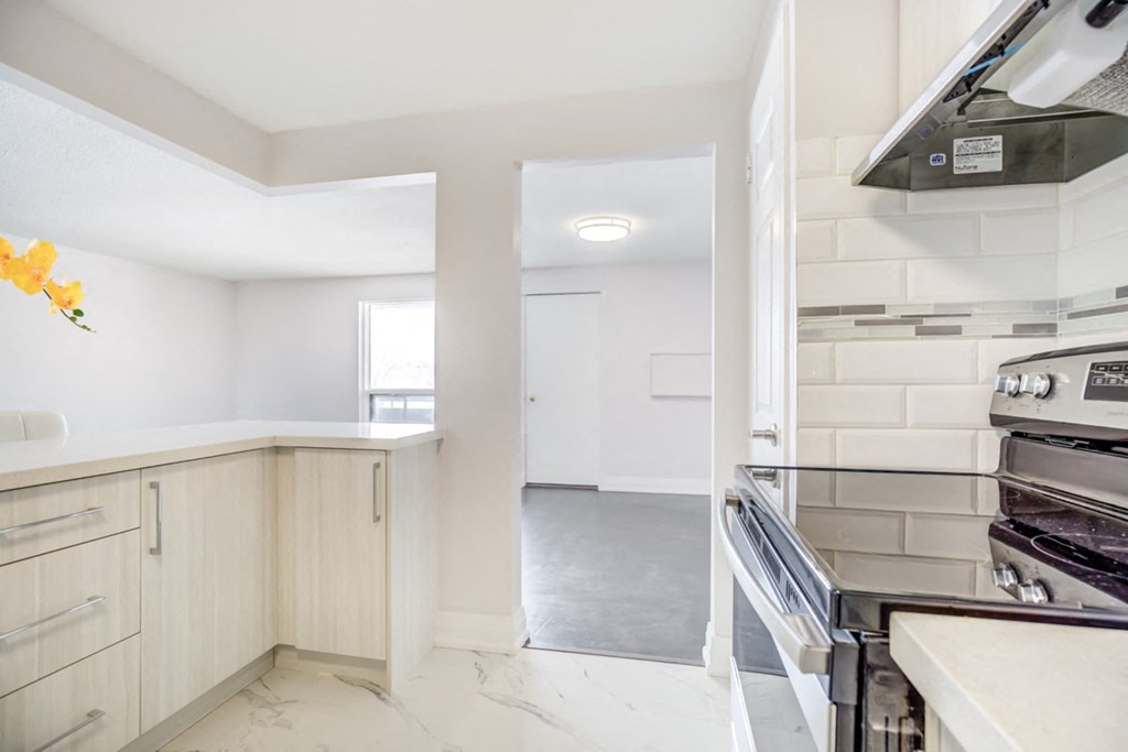 a renovated kitchen with white cabinets and stainless steel appliances