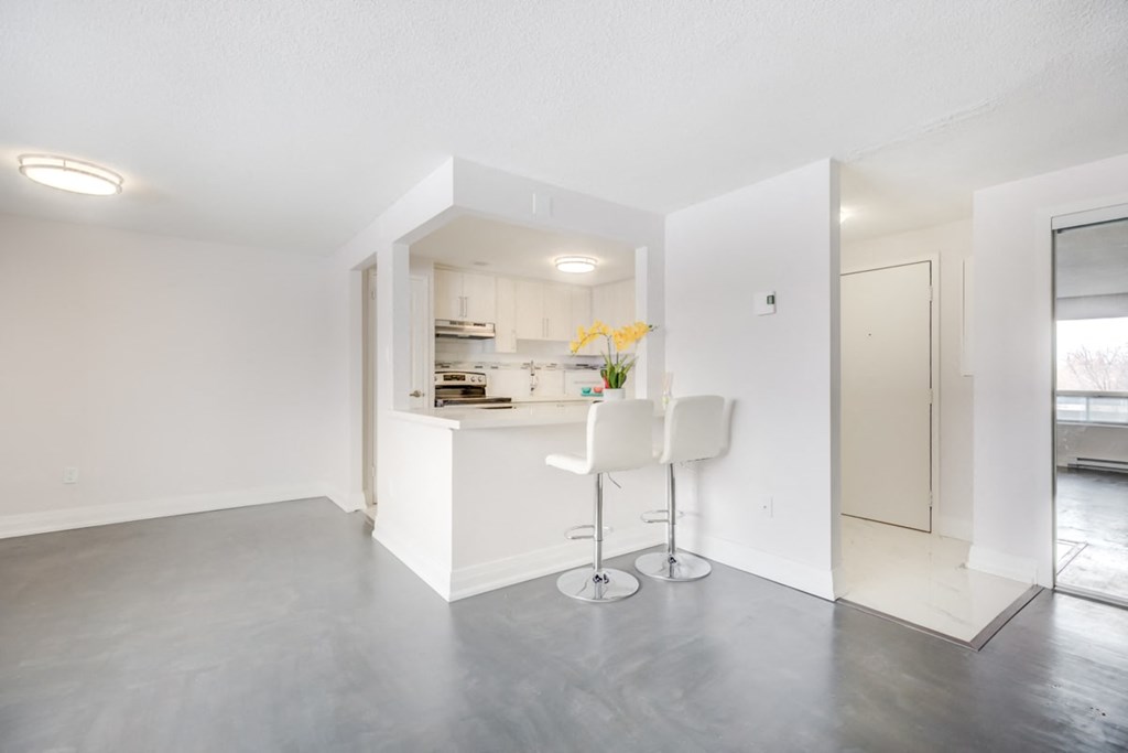 the living room and kitchen of an apartment with a bar