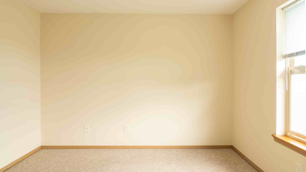 an empty room with two windows