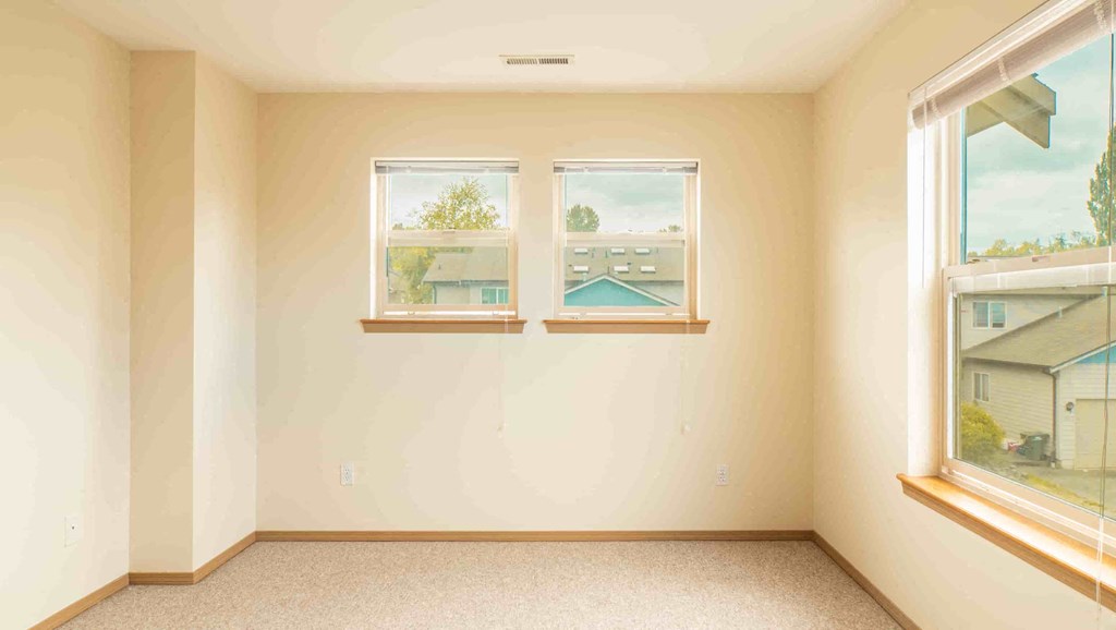 an empty room with three windows in it