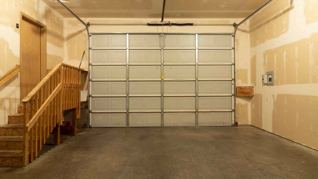 a large garage door in a building with a staircase