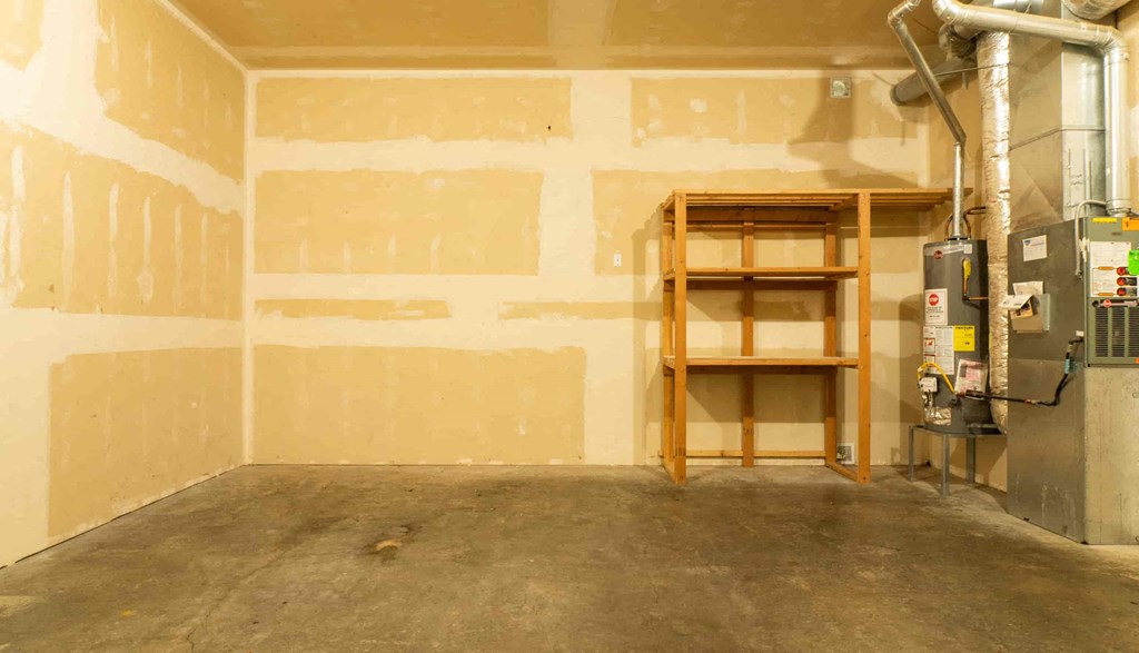 a room with unfinished walls and a heater and shelves
