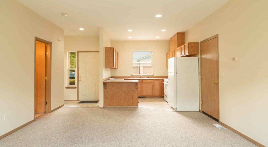 an empty kitchen with a refrigerator and a sink