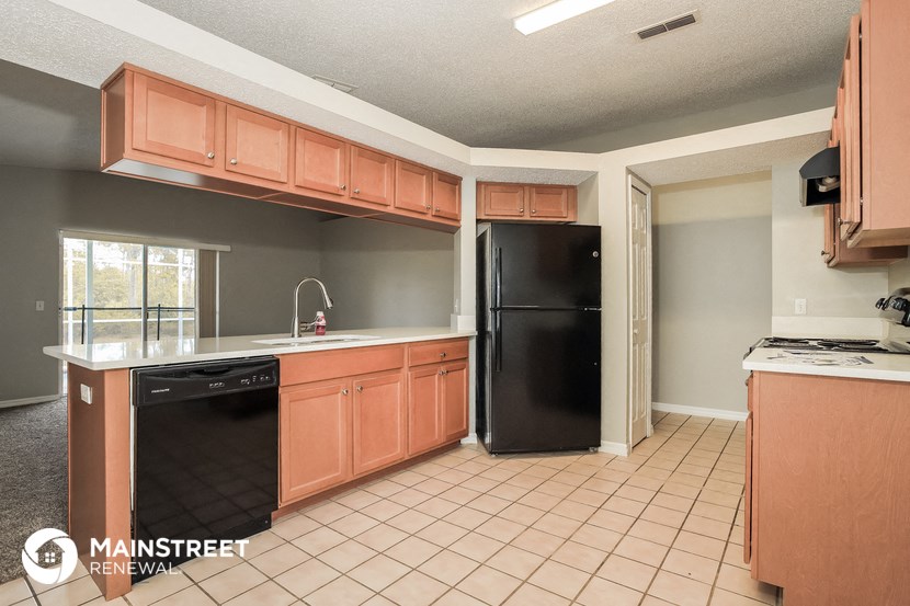 a kitchen with wooden cabinets and a black refrigerator