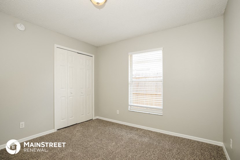the upstairs bedroom has carpet and a white door and window