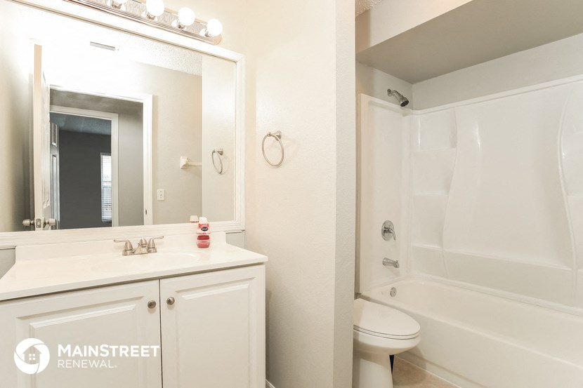 a bathroom with a shower sink and toilet and a mirror