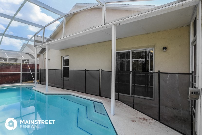 the pool is under a glass roof and next to a house with a pool