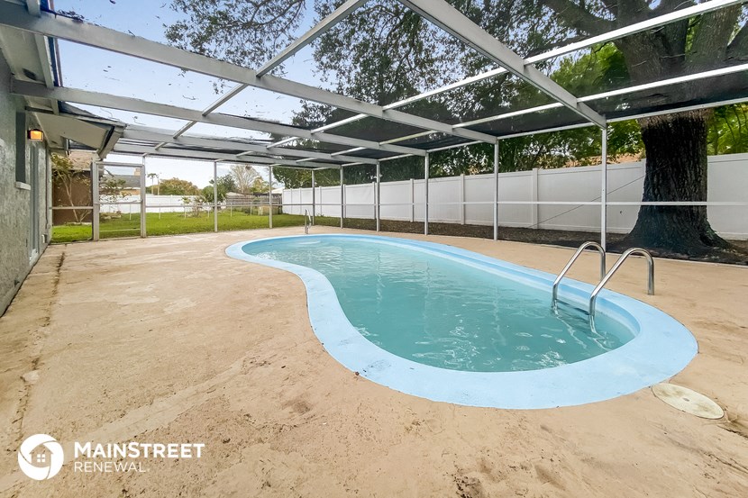 a hot tub is under a white roof in a backyard pool
