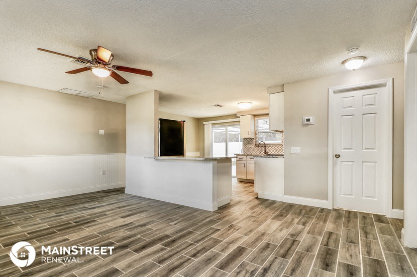an open kitchen and living room with a ceiling fan