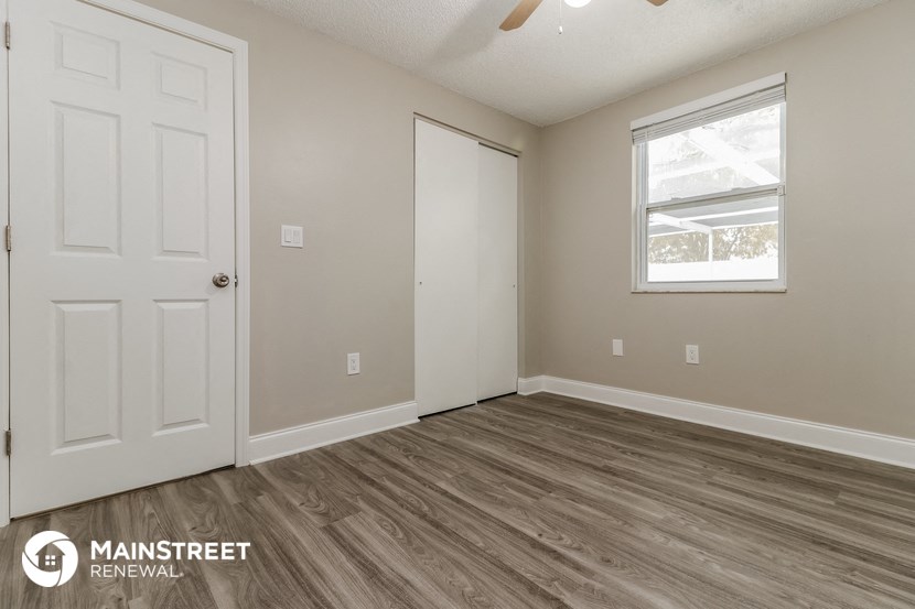 the living room of a home with a white door and a window