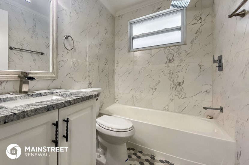 a white bathroom with a tub and a toilet and a sink