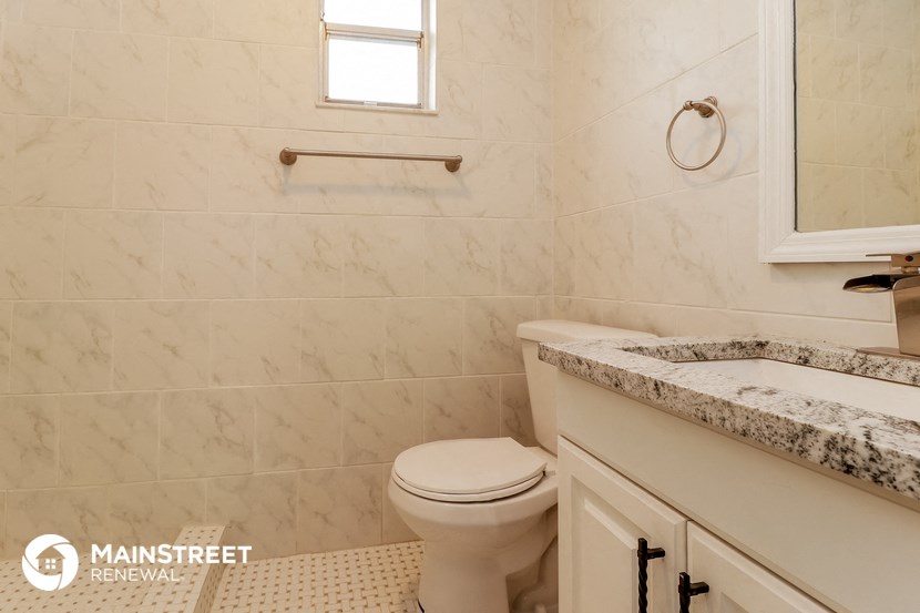 a bathroom with a toilet and a sink and a window