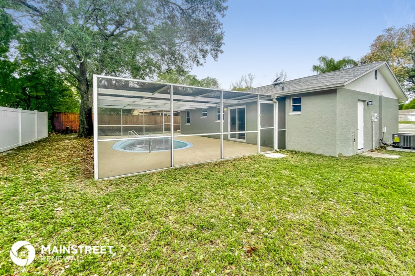 a backyard with a pool and a patio with a glass enclosure