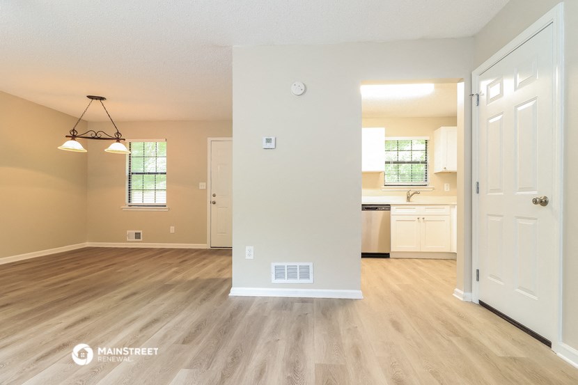 an open living room and kitchen with wood flooring