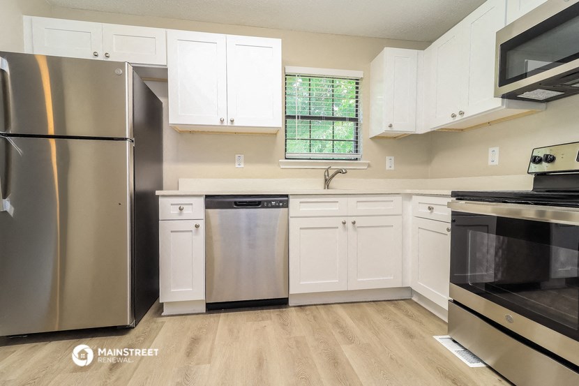 a kitchen with white cabinets and stainless steel appliances
