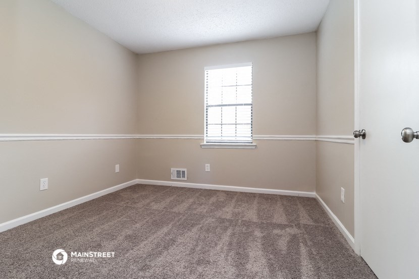 an empty room with carpet and a window