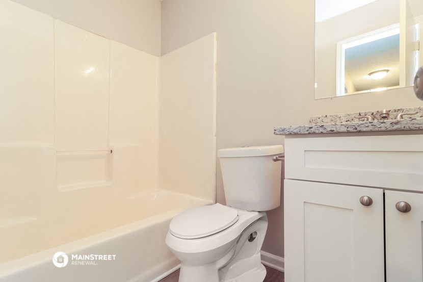 a bathroom with a toilet and a tub and a sink