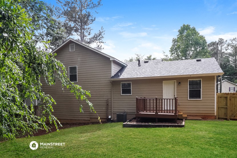a brown house with a deck and a yard